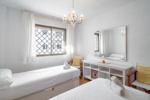 ネルハにあるCarabeo II 5 Apartments Casasolのベッドルーム1室(ベッド2台、鏡、窓付)