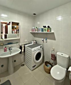 uma casa de banho com uma máquina de lavar roupa e um lavatório em Amanecer Isleño Habitaciones em Arrecife
