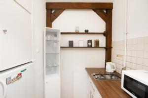 een keuken met witte muren en houten plafonds bij Amazing view and Great location. Ratusz Arsenal. in Warschau