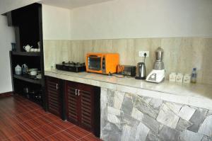 un forno a microonde arancione seduto su un bancone in cucina di Asantha Guest House a Unawatuna