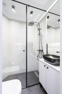 a white bathroom with a black sink and a toilet at Stunning Views Luxury Studio in Bucharest