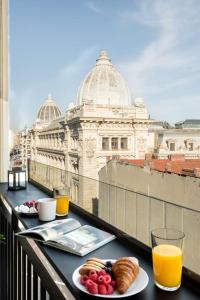 two plates of food on a balcony with a view of a building at Stunning Views Luxury Studio in Bucharest