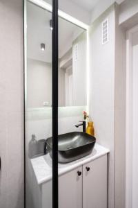 a bathroom with a black sink and a mirror at Stunning Views Luxury Studio in Bucharest +42 photos
