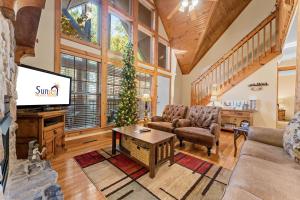 Una sala de estar con televisión y un árbol de Navidad. en River's Creek Cabin, en Branson West