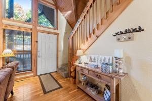 sala de estar con escalera y suelo de madera en River's Creek Cabin, en Branson West