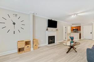 a living room with a clock on the wall at W - Atlanta Luxury 1bdr 1bath ensuite shared Condo in prime location in Atlanta