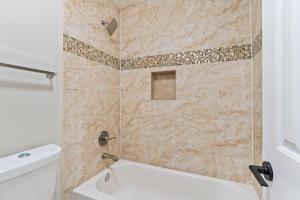 uma casa de banho com um chuveiro, uma banheira e um WC. em W - Atlanta Luxury 1bdr 1bath ensuite shared Condo in prime location em Atlanta