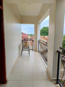 a balcony with a chair and a view at Twinkle Blue Inn in Namugongo