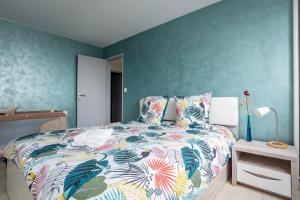 - une chambre avec un grand lit et un couvre-lit coloré dans l'établissement Famille, Parking, Balnéo - 15min Centre, à Strasbourg
