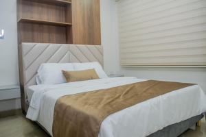 una camera da letto con un grande letto bianco e una finestra di Mar Apartamentos a Bucaramanga