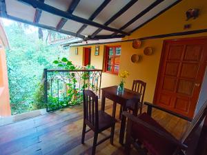 Wayras Hostal في أولانتايتامبو: غرفة طعام مع طاولة وكراسي وباب