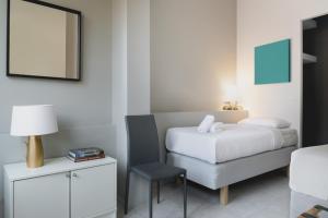 ein Hotelzimmer mit einem Bett und einem Stuhl in der Unterkunft Athens Soho Lofts -Evaggelistrias 18 in Athen
