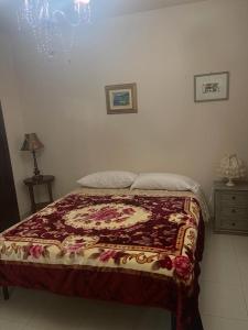 a bedroom with a bed with a red and white blanket at Villa Chiara B&B in Civitavecchia