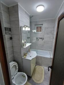 een badkamer met een toilet, een wastafel en een bad bij sweethomegalati in Galaţi