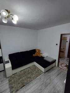 um urso de peluche sentado num sofá na sala de estar em sweethomegalati em Galaţi