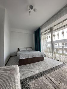 1 dormitorio con 2 camas y ventana grande en Таунхаус в Baytur Resort, en Bosteri