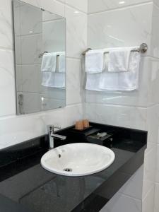a bathroom with a sink and a mirror and towels at Đoàn Gia Luxury House in Pleiku