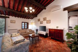 a living room with a couch and a tv at Tenuta Aronne in Massa Marittima