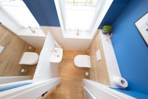 La salle de bains est pourvue de toilettes blanches et d'un plafond bleu. dans l'établissement VacationClub – Lipowa 1 Apartament 3, à Wisła