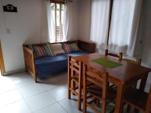 sala de estar con mesa y sofá en cabañas del bosque en Pinamar