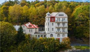 una gran casa blanca con techo rojo en Hotel Dagmar en Jáchymov