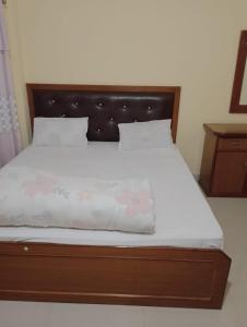 1 cama con cabecero de madera en un dormitorio en Hotel aradhya en Lumbini