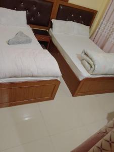 two beds sitting next to each other in a room at Hotel aradhya in Lumbini