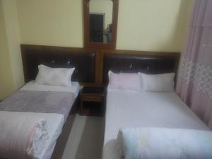 Habitación de hotel con 2 camas y espejo en Hotel aradhya en Lumbini