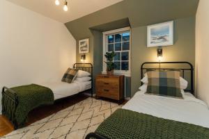 1 dormitorio con 2 camas y ventana en The Old Deanston Workers Cottage en Doune