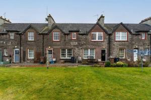 a large stone house with a large yard at The Old Deanston Workers Cottage in Doune