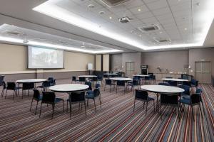 a room with tables and chairs and a projection screen at Wyndham Salvador Hangar Aeroporto in Salvador