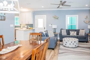 eine Küche und ein Wohnzimmer mit einem Tisch und einem Sofa in der Unterkunft Cottage Beach House Steps From Beach 3 bedroom 2 bath in Gulf Shores