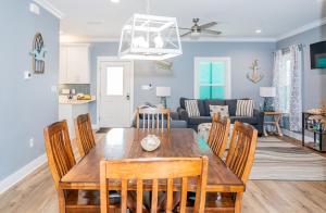 a dining room and living room with a table and chairs at Cottage Beach House Steps From Beach 3 bedroom 2 bath in Gulf Shores