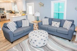 ein Wohnzimmer mit 2 Sofas und einem Tisch in der Unterkunft Cottage Beach House Steps From Beach 3 bedroom 2 bath in Gulf Shores