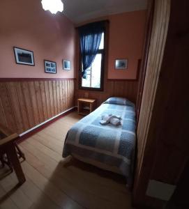 a bedroom with a bed and a window at Hostal Florencia in Puerto Varas