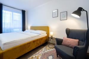 Moravská Ostrava的住宿－Nova Karolina Apartment，一间卧室配有一张床和一把椅子