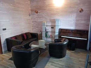 科托努Magnifique appartement的带沙发和钢琴的客厅