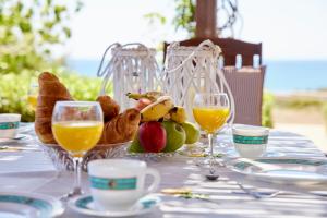 einen Tisch mit einem Korb mit Speisen und Gläsern Orangensaft in der Unterkunft Edem Paradise in Plimmiri