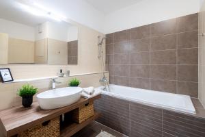 een badkamer met een wastafel en een bad bij Nova Karolina Apartment in Moravská Ostrava