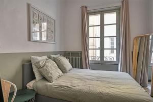 uma cama num quarto com uma janela em Au cœur d'Avignon - 2 mins du Palais - Terrasse isolée em Avignon