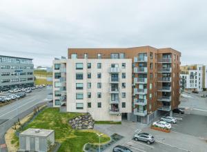 eine Luftansicht eines Gebäudes mit einem Parkplatz in der Unterkunft Glacial Properties, Cozy apartment in Kópavogur in Reykjavík