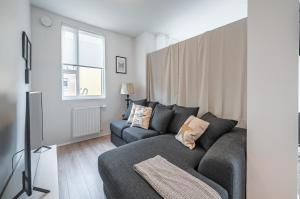 ein Wohnzimmer mit einem grauen Sofa und einem Fenster in der Unterkunft Glacial Properties, Cozy apartment in Kópavogur in Reykjavík