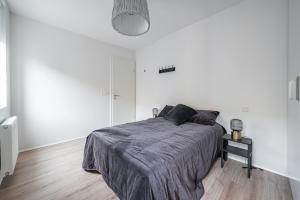 ein weißes Schlafzimmer mit einem Bett mit einer grauen Decke in der Unterkunft Glacial Properties, Cozy apartment in Kópavogur in Reykjavík