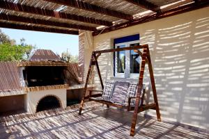 een schommel op de veranda van een huis met een open haard bij Edem Paradise in Plimmiri
