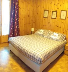 een slaapkamer met een bed in een houten muur bij Casa Felice in Valfurva