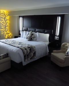 a bedroom with a large bed and a chair at Dockside Suites in Digby