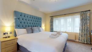 a bedroom with a large bed and a large window at Stirk House Hotel in Clitheroe