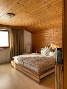 Schlafzimmer mit einem Bett mit Holzdecke in der Unterkunft Haus Reichlas in Längenfeld