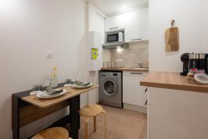 a kitchen with a table and a washing machine at Le Mimi Mosa - Parking public gratuit, wifi haut débit, proche autoroute, gare & centre ville in Mâcon