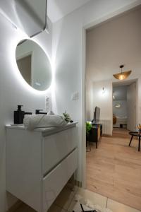 La salle de bains blanche est pourvue d'un lavabo et d'un miroir. dans l'établissement Le Mimi Mosa - Parking public gratuit, wifi haut débit, proche autoroute, gare & centre ville, à Mâcon